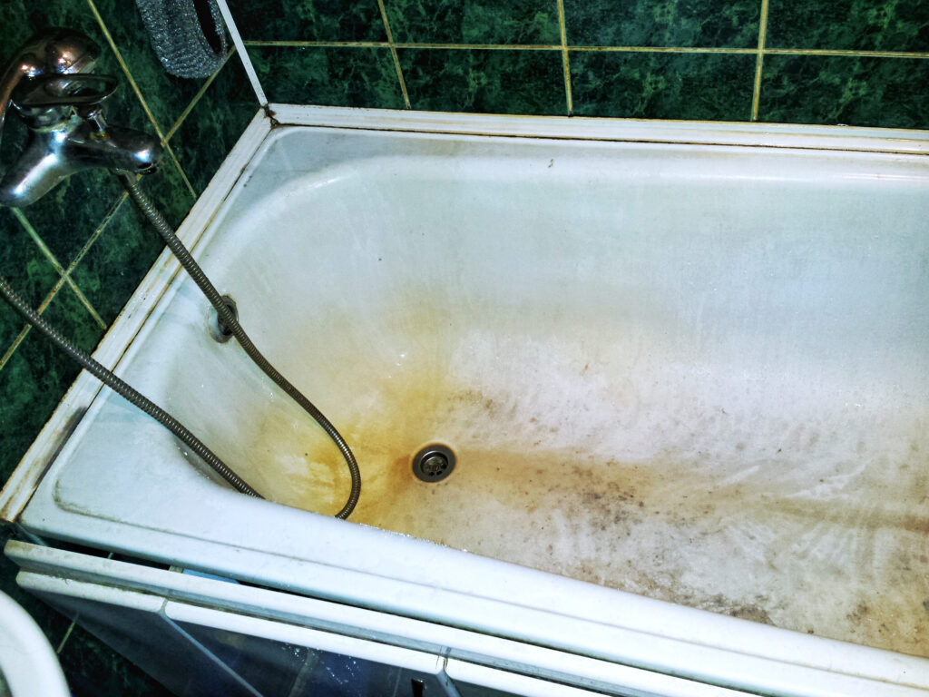 Cast iron bathtub rust spots before and after professional refinishing in Baltimore Maryland historic home